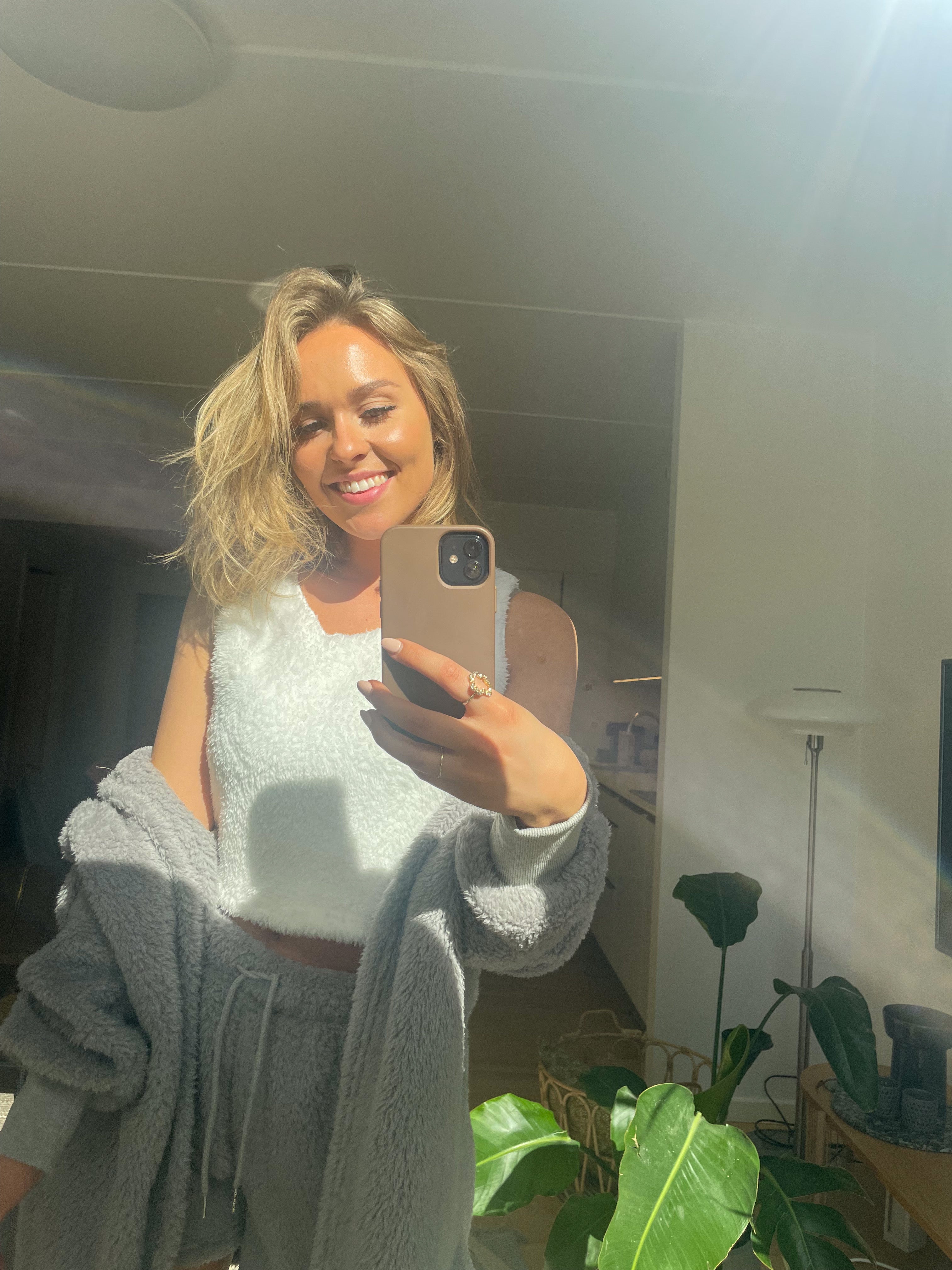 Et billede af en smilende dame med hyggetøj på.